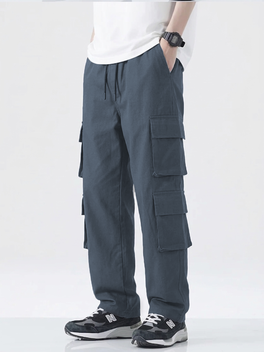 Person wearing gray cargo pants on a white background