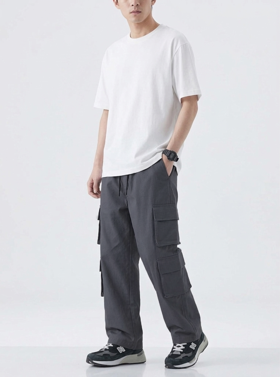 Person wearing a white t-shirt and dark gray cargo pants on a white background